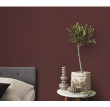 Slaapkamer met bed, nachtkastje en decoratief wandbehang voor een gezellige sfeer.