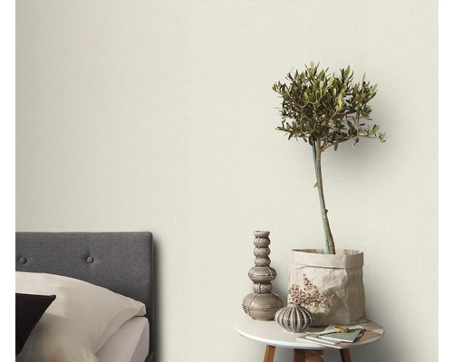 Slaapkamer met bed, bijzettafel en decoratieve elementen zoals een plant en vazen