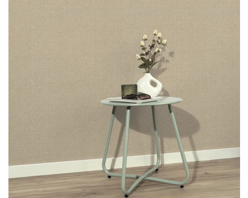 Scene met tafel, decoratie en beige vliesbehang op de achtergrond.