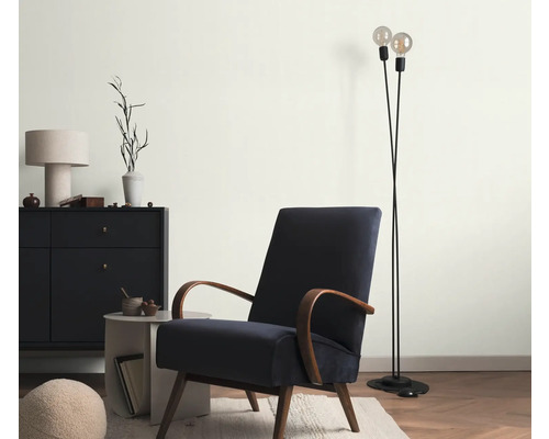 Woonkamer met fauteuil, vloerlamp en dressoir voor een gezellige sfeer.