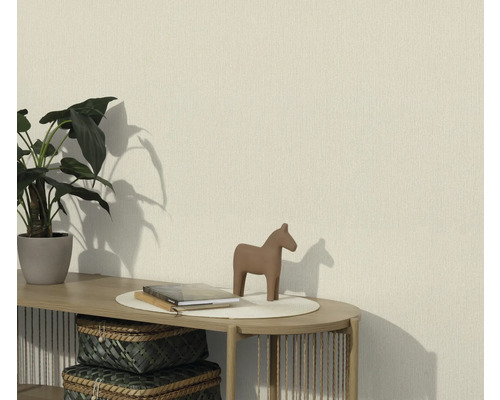 Woonkamer met een gestructureerd behang, gedecoreerd met een plant, een paardenbeeld en boeken op een tafel
