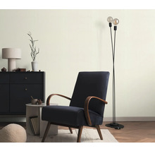 Woonkamer met fauteuil, staande lamp en dressoir voor een stijlvolle sfeer