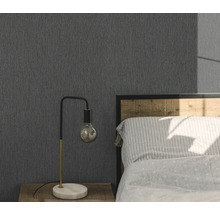 Slaapkamer met grijs structuurbehang, nachtkastje en lamp.