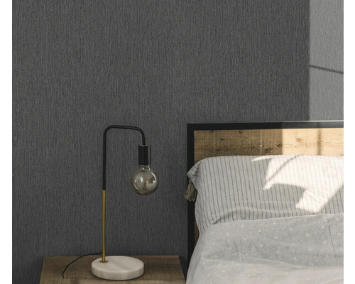 Slaapkamer met grijs structuurbehang, nachtkastje en lamp.