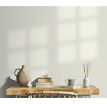 Lichte werkkamer met bureau, stapel boeken, vazen en een mok