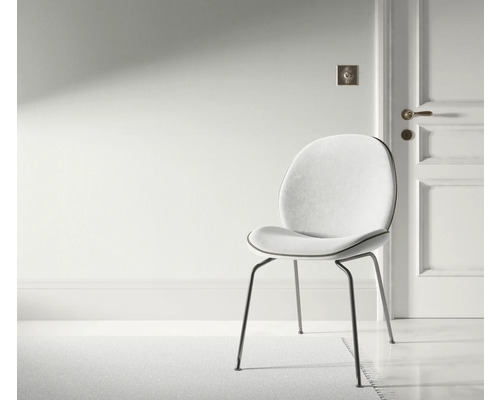 Scene met een stoel met metalen poten en een gestoffeerde zitting in een heldere ruimte.