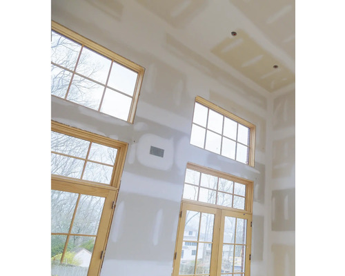 Interieur van een kamer met gipsplaten wanden en houten kozijnen