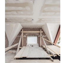 Zolderverbouwing met bakstenen muur en bouwhout