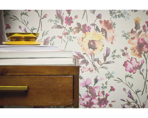 Detailopname van een behang met bloemmotief naast een nachtkastje