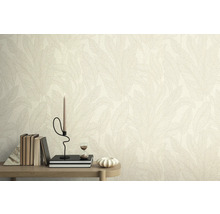 Muur met behang met bladmotief, versierd met boeken, kaars en zandloper op een tafel.