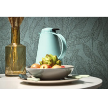 Decoratief stilleven met vaas, thermoskan en fruitschaal voor een behang met bladmotief.