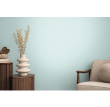 Woonkamer met fauteuil, houten tafel en decoratieve vaas