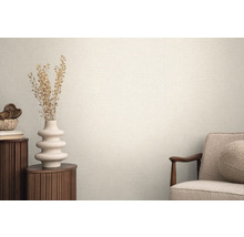 Lichte ruimte met gestructureerd behang, gedecoreerd met een vaas en een fauteuil voor een huiselijke sfeer.