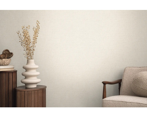 Lichte ruimte met gestructureerd behang, gedecoreerd met een vaas en een fauteuil voor een huiselijke sfeer.