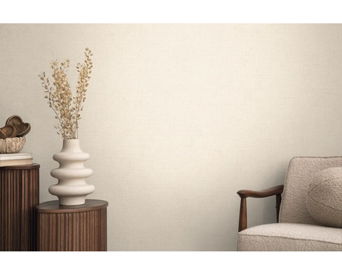 Woonkamer met textielbehang, fauteuil, ronde bijzettafel en decoratie