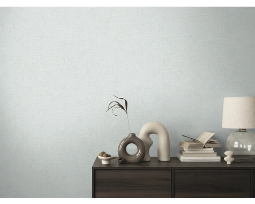 Woonkamer met patroonbehang en dressoir met decoratieve elementen.