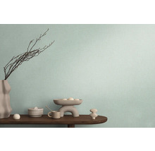 Decoratieve opstelling op een houten tafel voor een wand met textielbehang