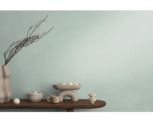 Decoratieve opstelling op een houten tafel voor een wand met textielbehang