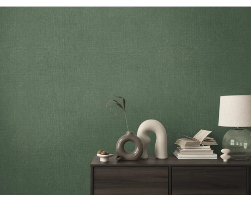 Detailopname van een groen textielbehang op een muur achter een kast.