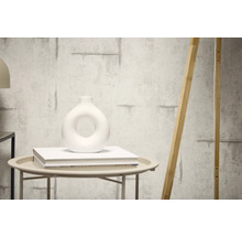 Decoratieve muur met cementstructuur en een houten element dat ertegenaan leunt.