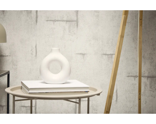 Decoratieve muur met cementstructuur en een houten element dat ertegenaan leunt.