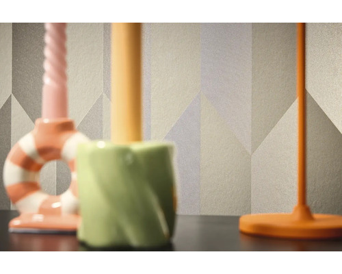 Close-up van een behang met patroon en geometrische vormen op de achtergrond van drie kandelaars.