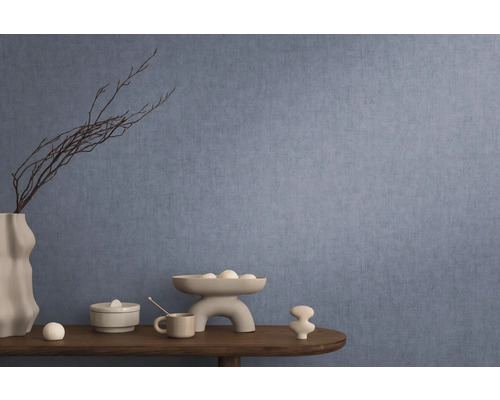 Decoratief interieur met blauw behang, tafel met decoraties zoals vaas, schaal en keramische figuren