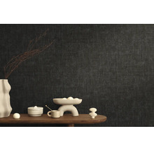 Stijlvolle kamerinrichting met donker vliesbehang en decoratieve elementen op een houten tafel.