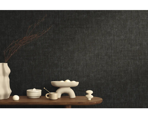 Stijlvolle kamerinrichting met donker vliesbehang en decoratieve elementen op een houten tafel.