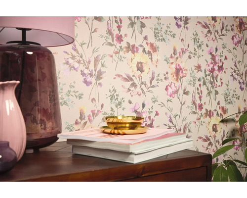 Woonkamerscène met bloemenbehang, tafellamp, vazen, boeken en schaal.