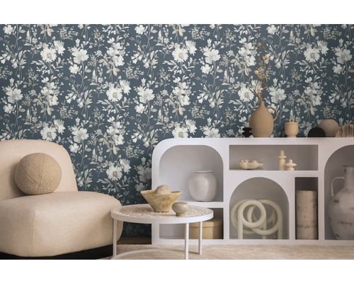 Woonkamer met bloemetjesbehang, fauteuil en witte kast