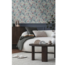 Woonkamer met bloemenbehang, bank, tafel en decoraties voor een gezellige sfeer.