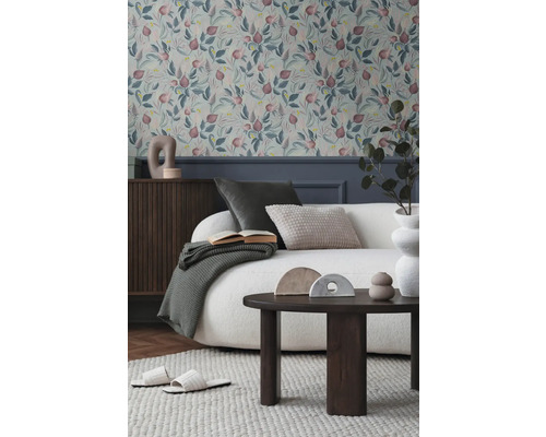 Woonkamer met bloemenbehang, bank, tafel en decoraties voor een gezellige sfeer.