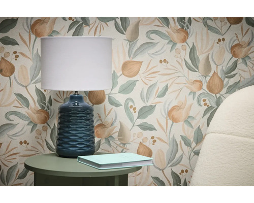 Scène met bloemmotief behang, tafellamp en boek op bijzettafel