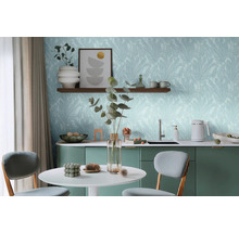 Lichte ruimte met tafel, stoelen en kitchenette voor een wand met bladerbehang.