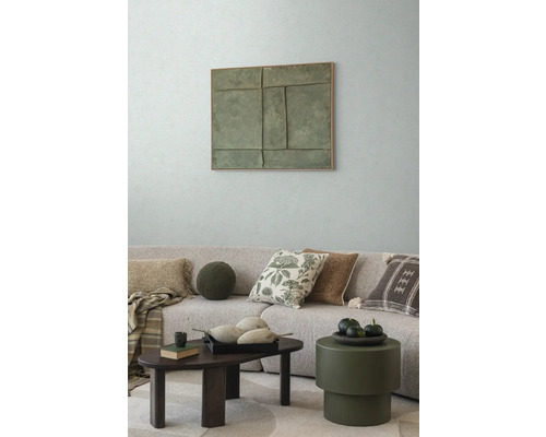 Woonkamer met bank, kussens, salontafel en wanddecoratie voor een gezellige sfeer