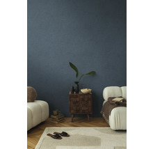 Woonkamer met gestructureerde blauwe muren, tapijt, meubels en decoratieve items