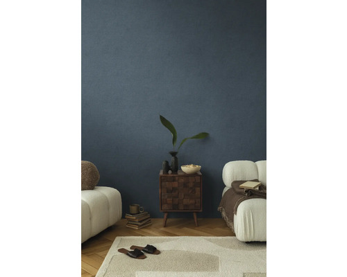 Woonkamer met gestructureerde blauwe muren, tapijt, meubels en decoratieve items