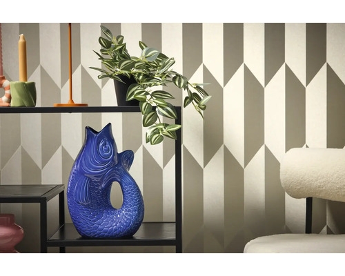 Decoratief interieur met plank, plant en visvaas tegen een geometrisch behang.