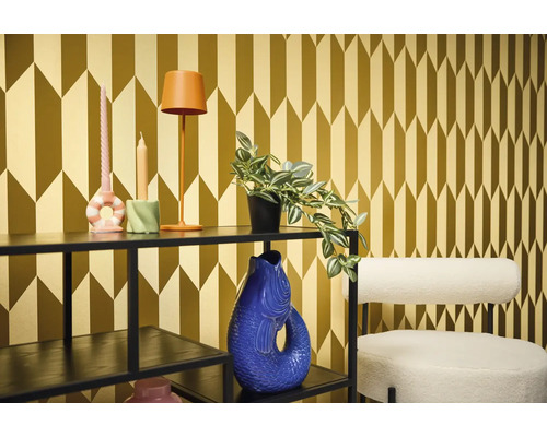 Decoratieve kamer met plank, lamp, kaarsen, plant, vaas en stoel voor een gedessineerd behang