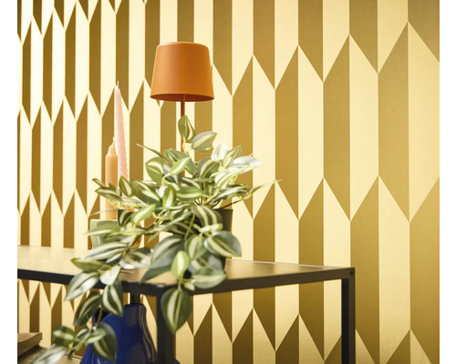 Decoratief goudkleurig behang met geometrisch pijldesign in een interieur.