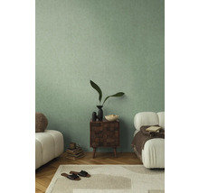 Lichte woonkamer met groene wand, houten nachtkastje en banken