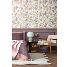 Slaapkamer met bloemenbehang, bed, fauteuil en nachtkastje