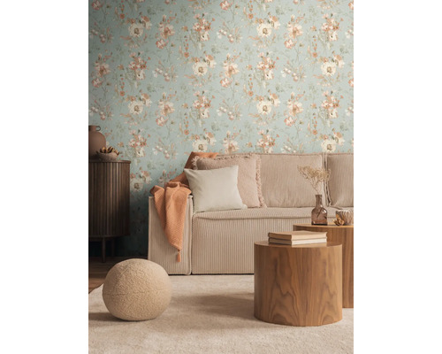 Woonkamer met bloemenbehang, ribfluwelen bank en houten tafels