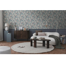 Woonkamer met patroonbehang, bank, vloerkleed en houten elementen voor een gezellige sfeer