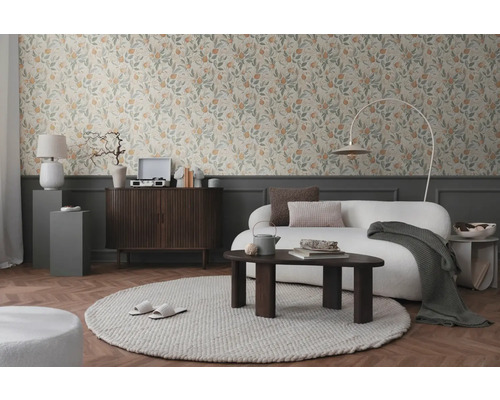 Woonkamer met bloemenbehang, bank, vloerkleed en houten meubels voor een gezellige sfeer.