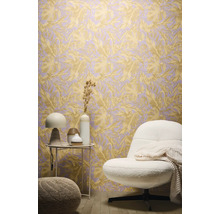 Inrichtingsvoorbeeld met een behang met bladerenmotief, een fauteuil en een bijzettafel.