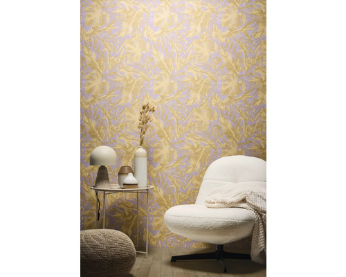 Inrichtingsvoorbeeld met een behang met bladerenmotief, een fauteuil en een bijzettafel.