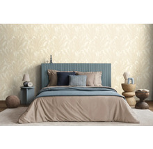 Een slaapkamer met een bed, nachtkastjes en een behang met print.