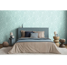 Slaapkamer met bed, nachtkastjes en behang met bladmotief voor een ontspannen sfeer.